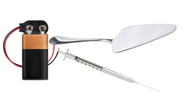 picture of a srynge and a cake shovel connected to a battery with wires